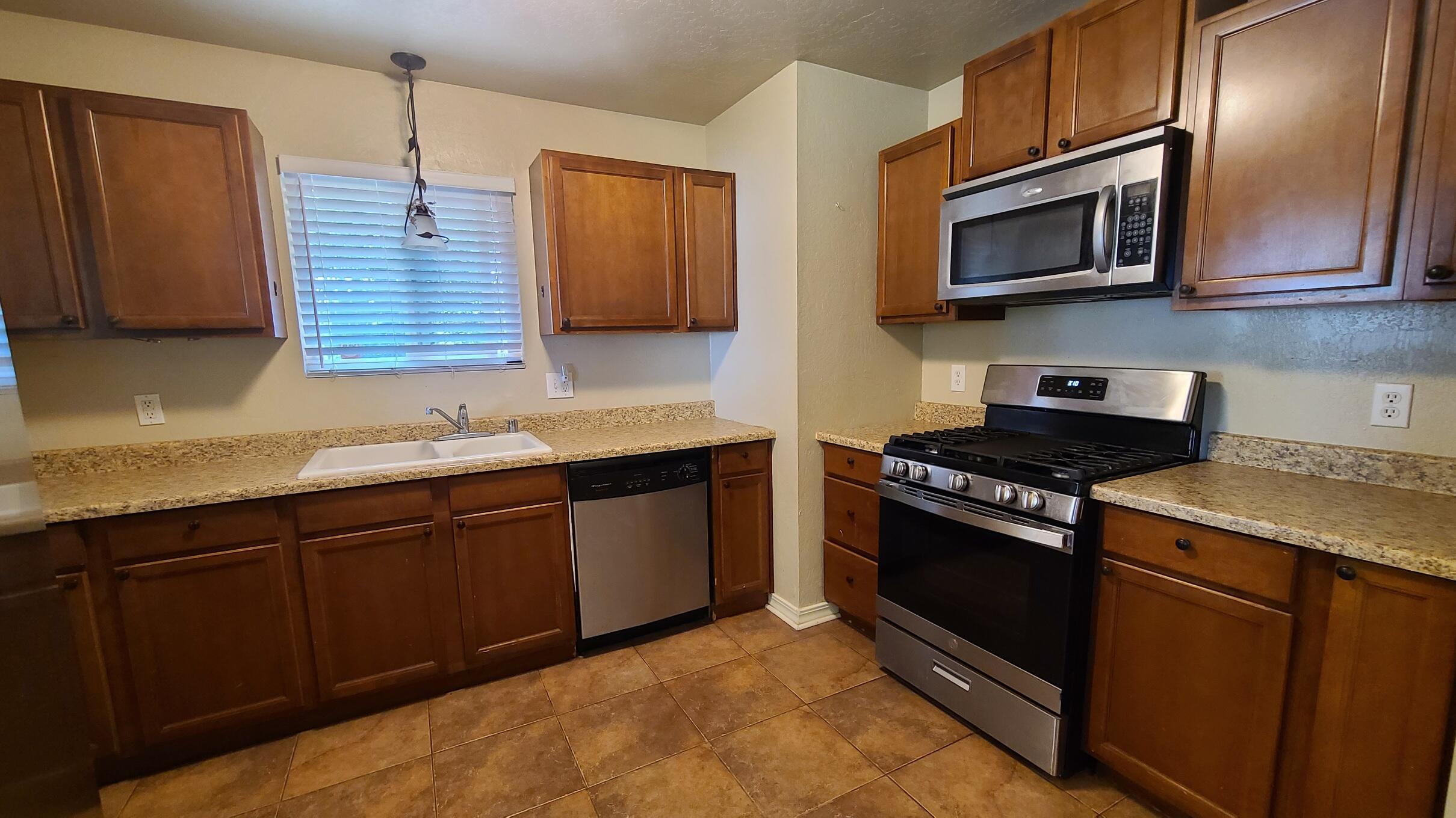 3175 Lawrence Road Redding, CA 96002 - Photo 4 of 18 a kitchen with stainless steel appliances granite countertop a stove microwave and sink