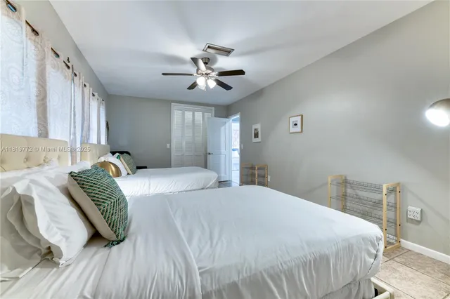 a bedroom with a bed ceiling fan and a window