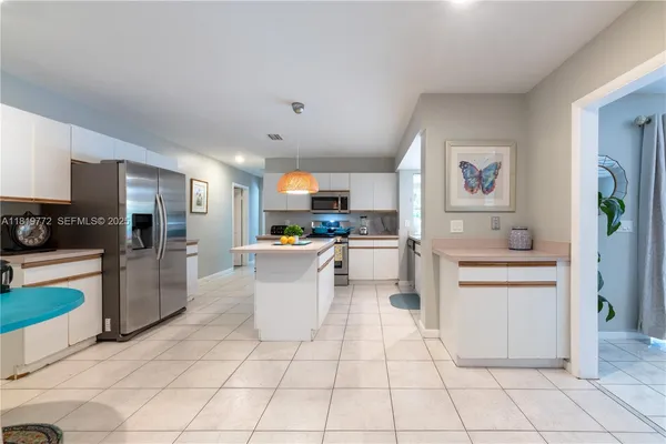 a large white kitchen with a stove a sink dishwasher and a refrigerator