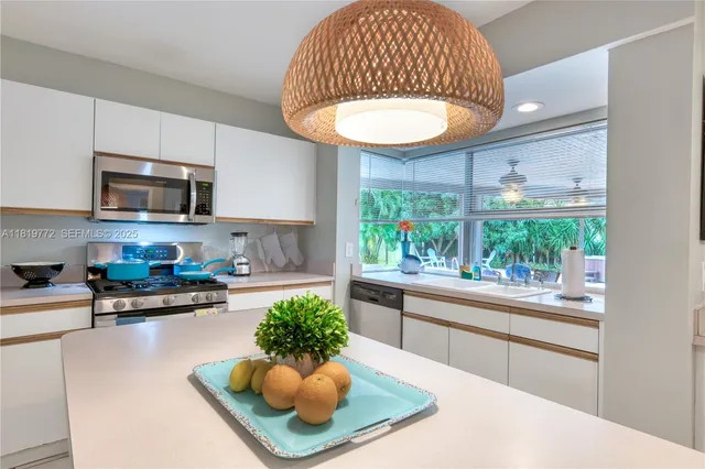 a kitchen with a sink a stove a microwave a dining table and chairs