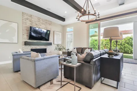 a living room with furniture a chandelier and a large window