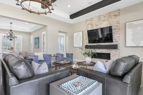 a living room with furniture a fireplace and a chandelier
