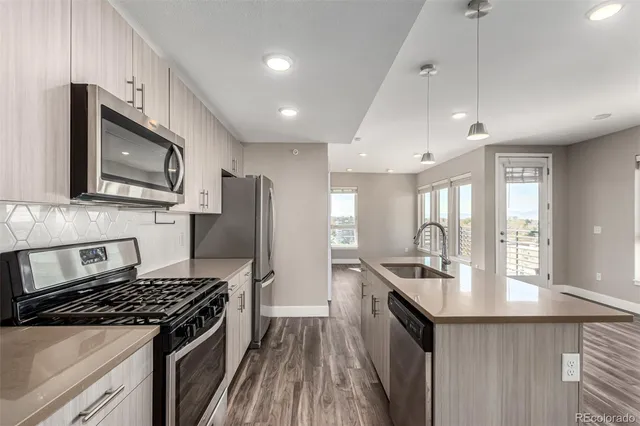 a kitchen with stainless steel appliances a sink stove and refrigerator