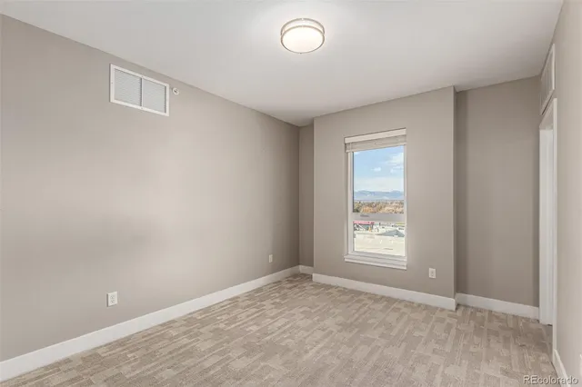 an empty room with windows and closet