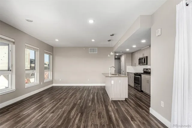 a view of a kitchen with wooden floor and electronic appliances
