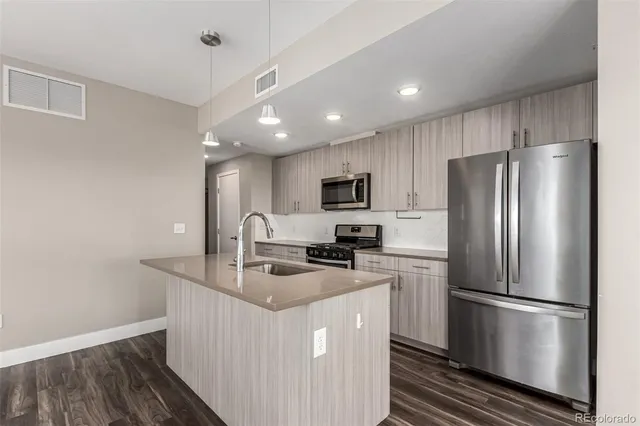 a kitchen with kitchen island a white cabinets a refrigerator and a stove