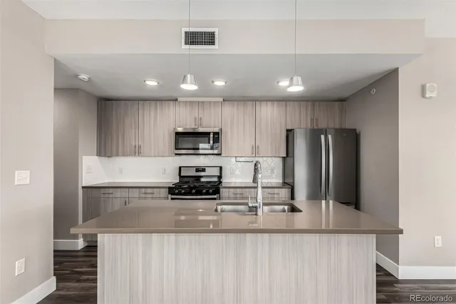 a kitchen with stainless steel appliances a refrigerator and a stove top oven