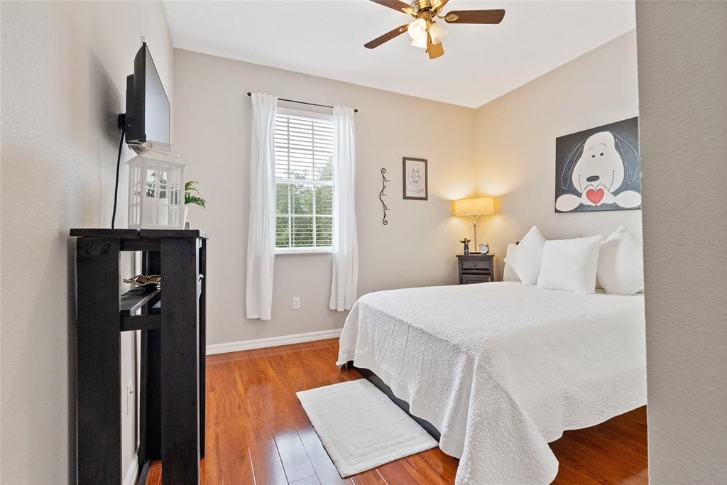 10475 Manderley Way Orlando, FL 32829 - Photo 22 of 31 a bedroom with a bed and a flat tv screen on the dresser