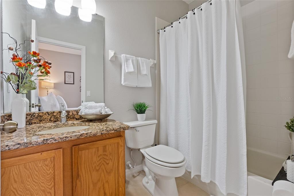 10475 Manderley Way Orlando, FL 32829 - Photo 23 of 31 a bathroom with a granite countertop sink and a mirror