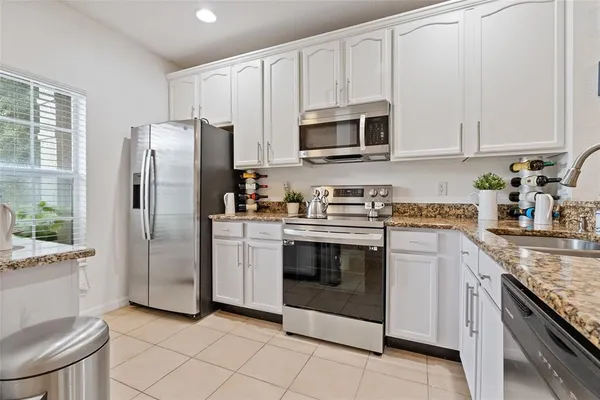 a kitchen with stainless steel appliances granite countertop a refrigerator sink and stove