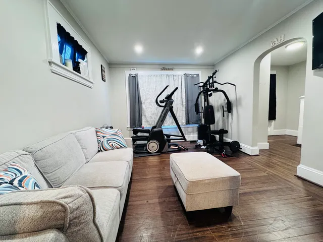 a living room with furniture gym equipment and view of living room