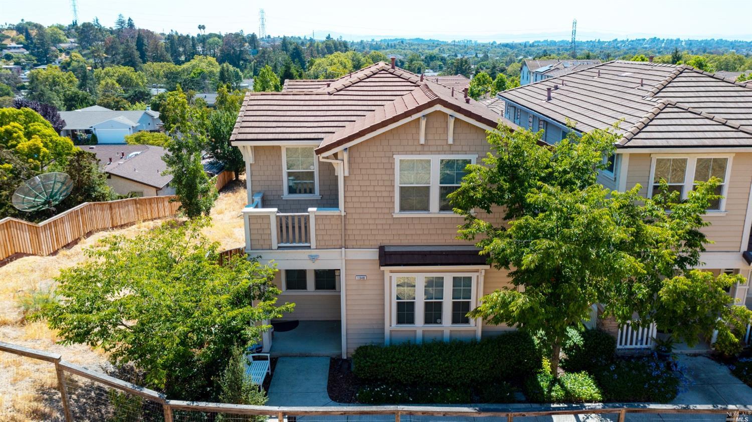 a front view of a house with a yard and potted plants