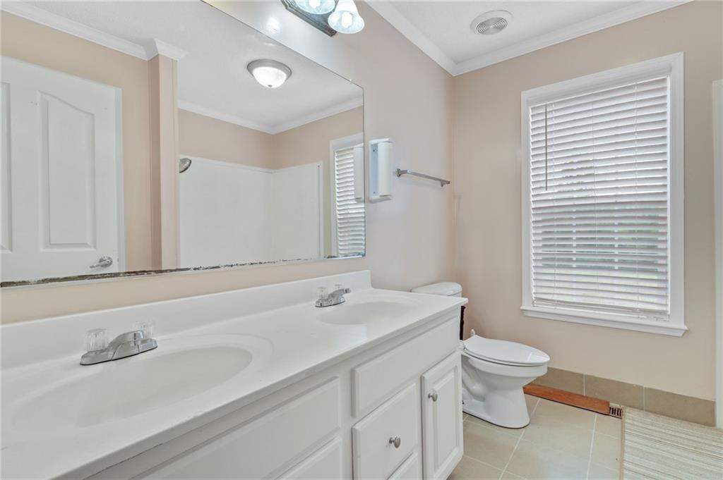 397 Reed Brawner Road Royston, GA 30662 - Photo 17 of 33 a bathroom with a toilet a sink a mirror and a window