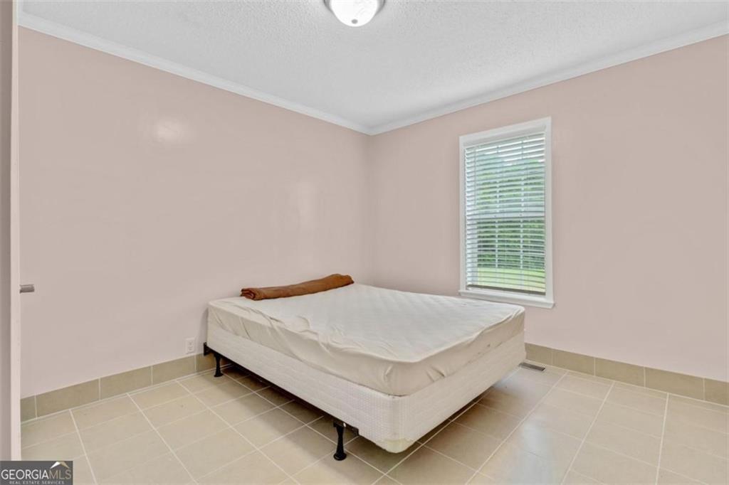 397 Reed Brawner Road Royston, GA 30662 - Photo 18 of 35 a bed sitting in a bedroom next to a window