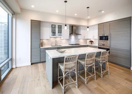 a kitchen with stainless steel appliances kitchen island granite countertop a table chairs sink and cabinets