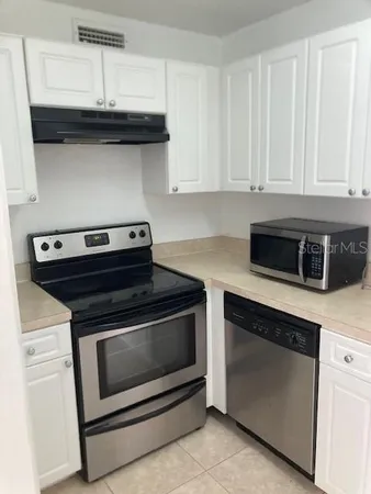 a stove top oven sitting inside of a kitchen