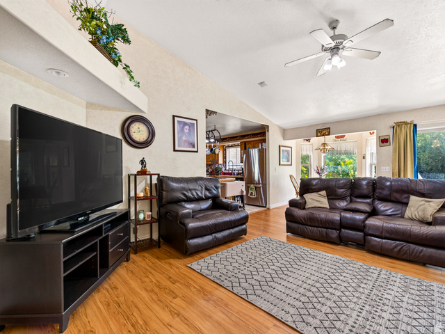 4380 Main Street Logan, UT 84321 - Photo 17 of 74 Family room with LVP flooring, vaulted ceiling, recessed lighting, and a ceiling fan with integrated lighting