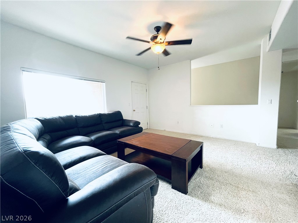 7701 West Robindale Road, Unit 206 Las Vegas, NV 89113 - Photo 7 of 30 Plush wall-to-wall carpeting and an open half-wall cutout define this comfortable main living space.