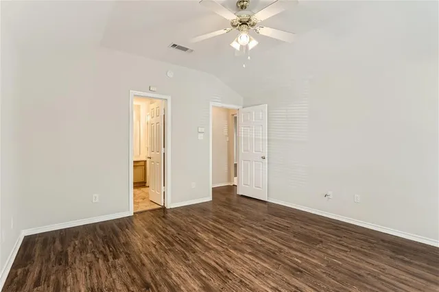 an empty room with wooden floor a ceiling fan and closet