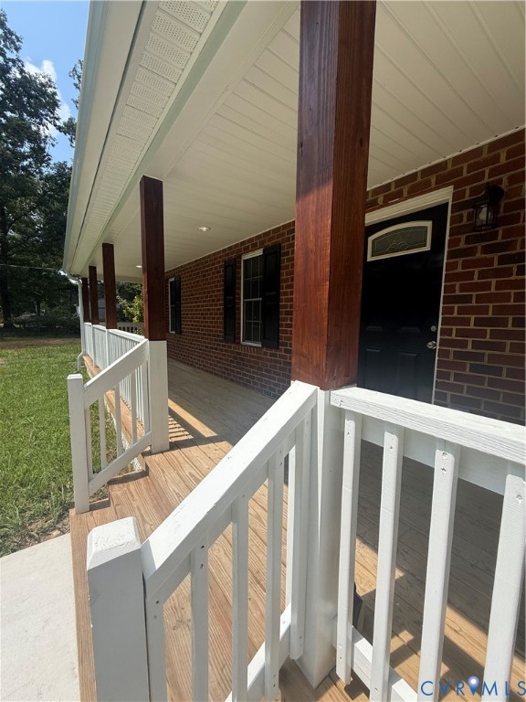 Expansive covered front porch with wood flooring,