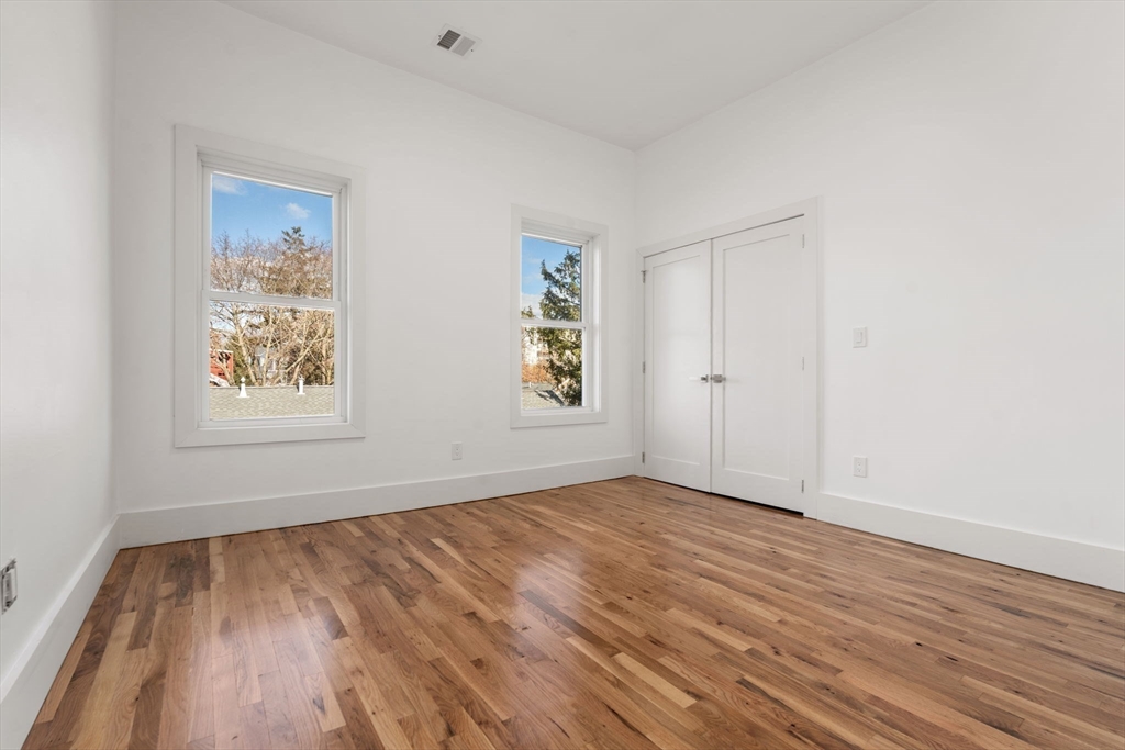 120 Regent Street, Unit 5 Boston, MA 02119 - Photo 11 of 27 an empty room with wooden floor and windows