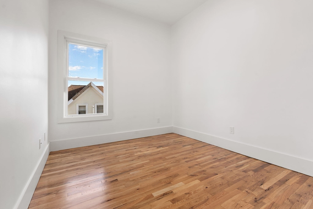 120 Regent Street, Unit 5 Boston, MA 02119 - Photo 13 of 27 a view of empty room with wooden floor and fan