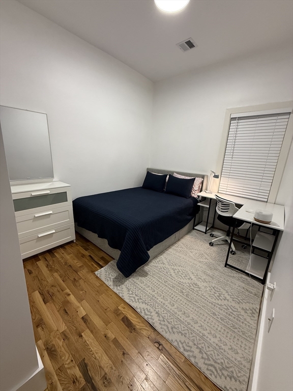 120 Regent Street, Unit 5 Boston, MA 02119 - Photo 18 of 27 a bedroom with a bed and wooden floor