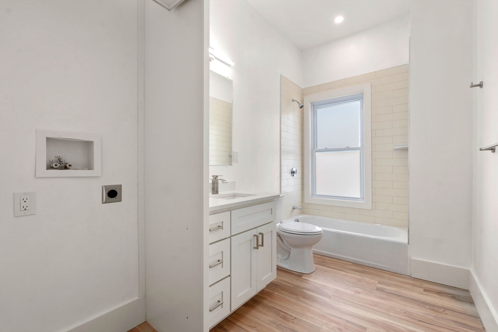 120 Regent Street, Unit 5 Boston, MA 02119 - Photo 9 of 27 a bathroom with a double vanity sink a toilet and a tub