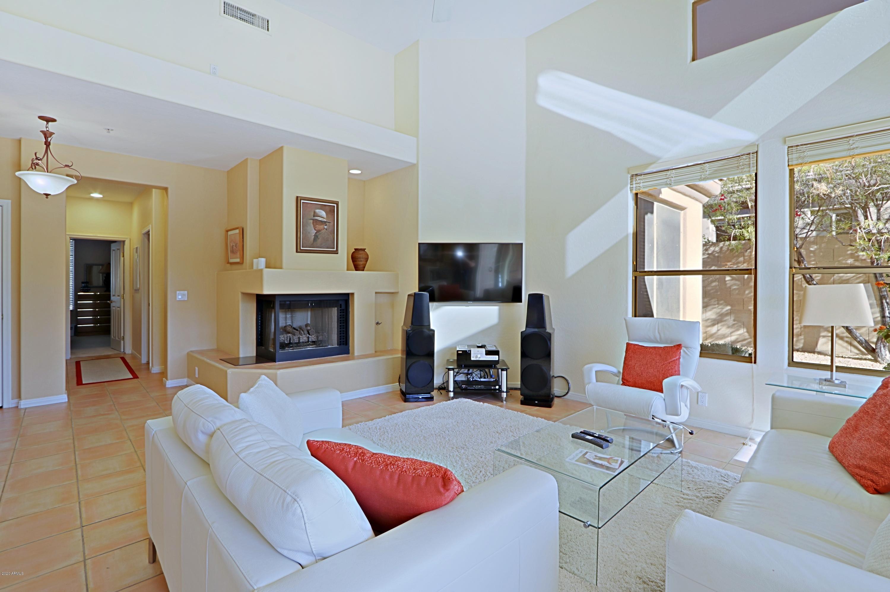 6803 East Eagle Feather Road Scottsdale, AZ 85266 - Photo 6 of 67 a living room with furniture flat screen tv and a fireplace