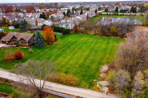 an aerial view of a house with a yard and lake view