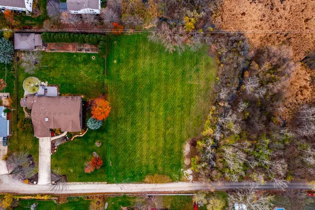 an aerial view of residential house with outdoor space and trees