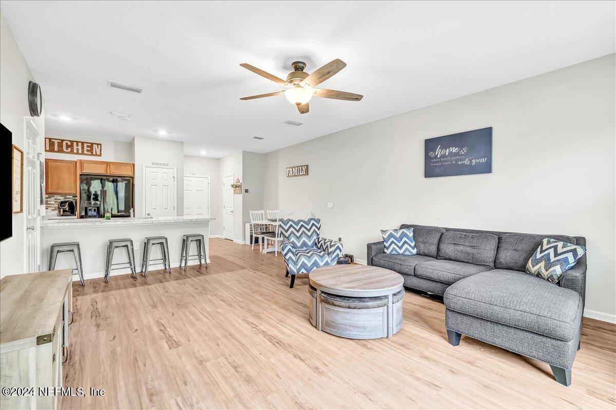 183 Silver Fern Drive St. Augustine, FL 32086 - Photo 12 of 29 a living room with furniture a flat screen tv and kitchen view