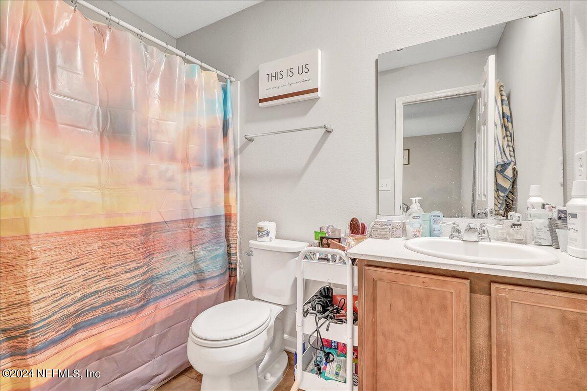 183 Silver Fern Drive St. Augustine, FL 32086 - Photo 21 of 29 a bathroom with a sink a toilet and a mirror