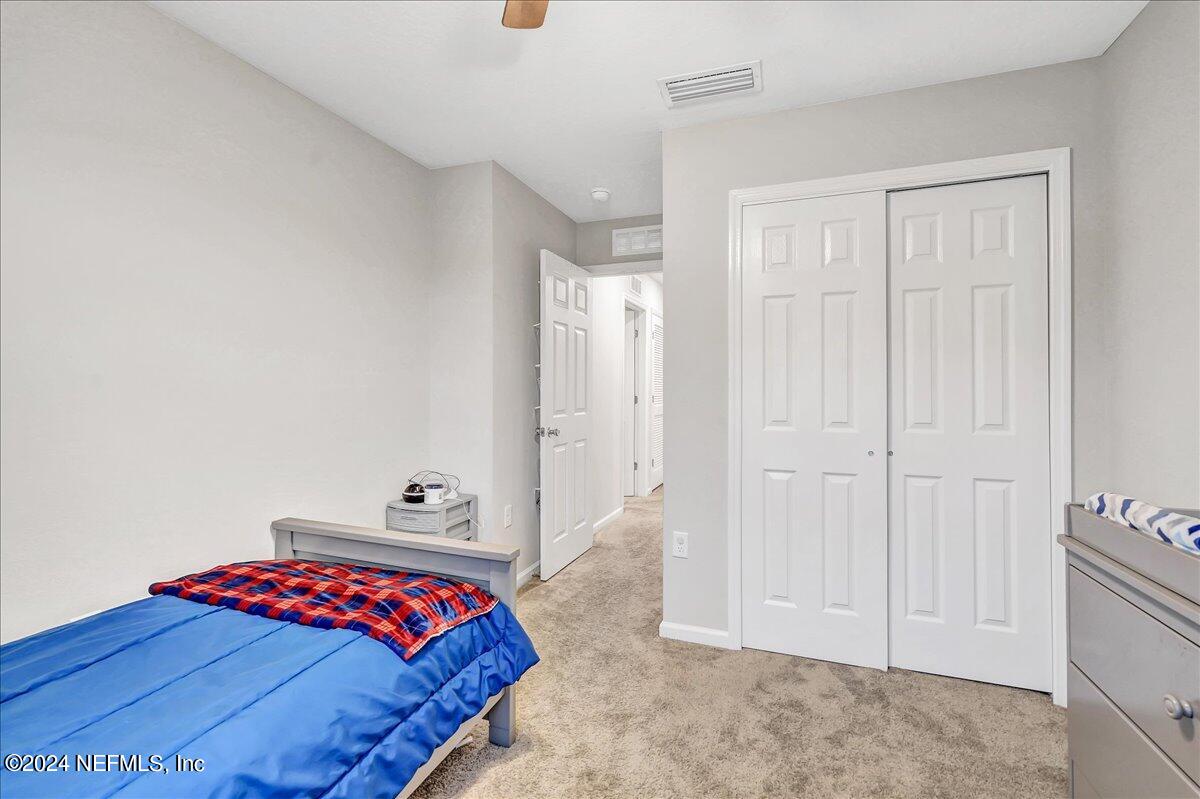 183 Silver Fern Drive St. Augustine, FL 32086 - Photo 24 of 29 a bedroom with a bed and a lamp