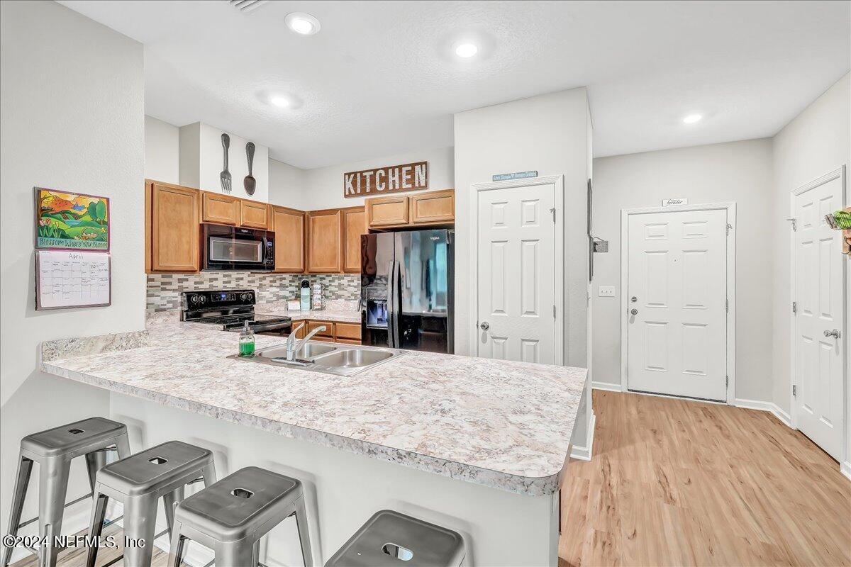 183 Silver Fern Drive St. Augustine, FL 32086 - Photo 9 of 29 a kitchen with granite countertop a sink cabinets and wooden floor