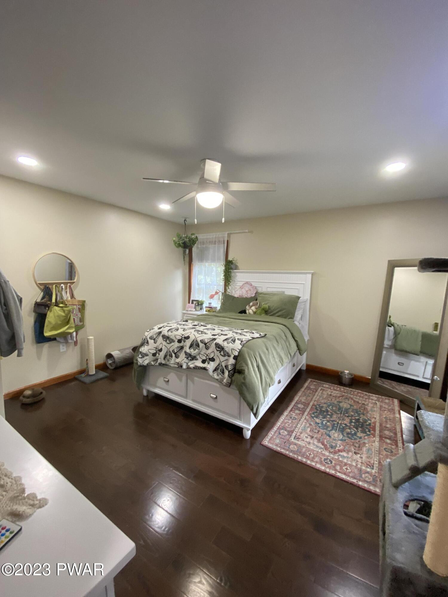 126 Maple Ridge Road Milford, PA 18337 - Photo 41 of 52 a bedroom with a bed and a night stand with wooden floor