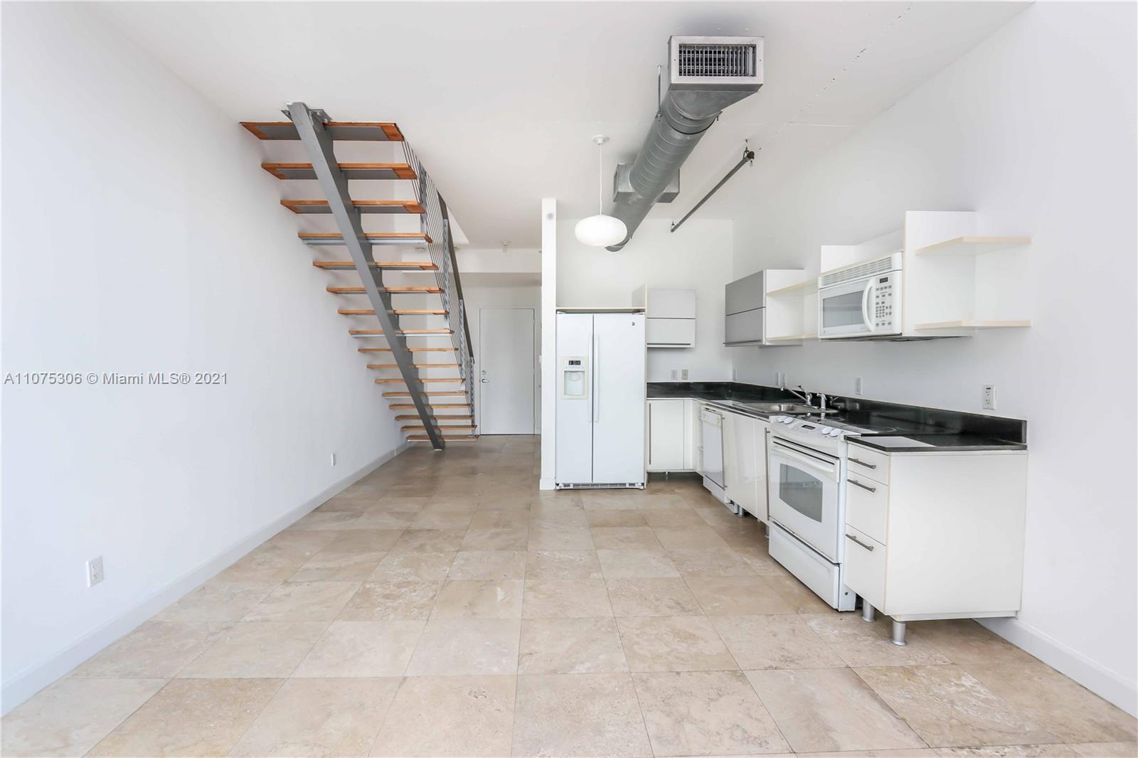 690 Southwest 1st Court, Unit 1715 Miami, FL 33130 - Photo 11 of 42 a kitchen with granite countertop a stove and a refrigerator
