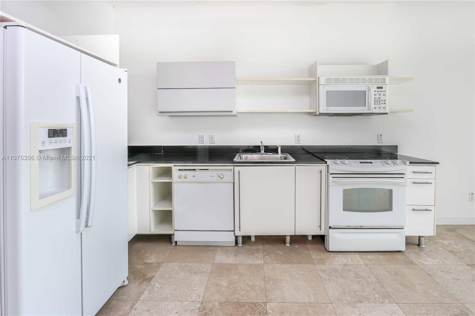 690 Southwest 1st Court, Unit 1715 Miami, FL 33130 - Photo 15 of 42 a white stove top oven and cabinets
