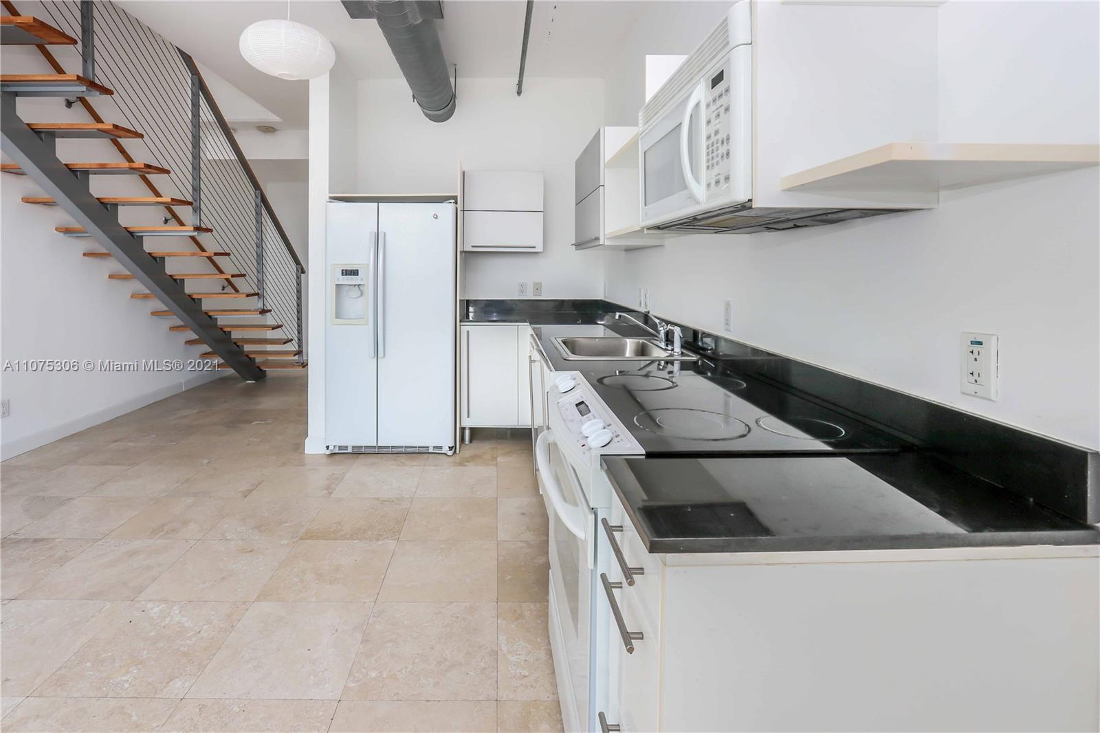 690 Southwest 1st Court, Unit 1715 Miami, FL 33130 - Photo 16 of 42 a kitchen with a cabinets and white appliances