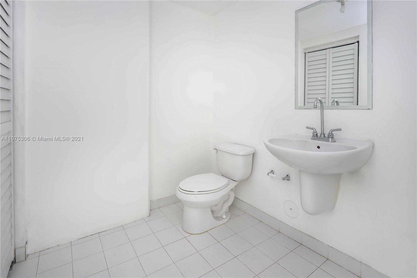 690 Southwest 1st Court, Unit 1715 Miami, FL 33130 - Photo 20 of 42 a bathroom with a sink toilet and mirror