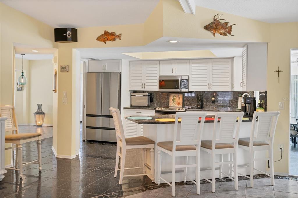 245 Spaniards Road Placida, FL 33946 - Photo 21 of 65 a kitchen with stainless steel appliances kitchen island granite countertop a refrigerator and microwave