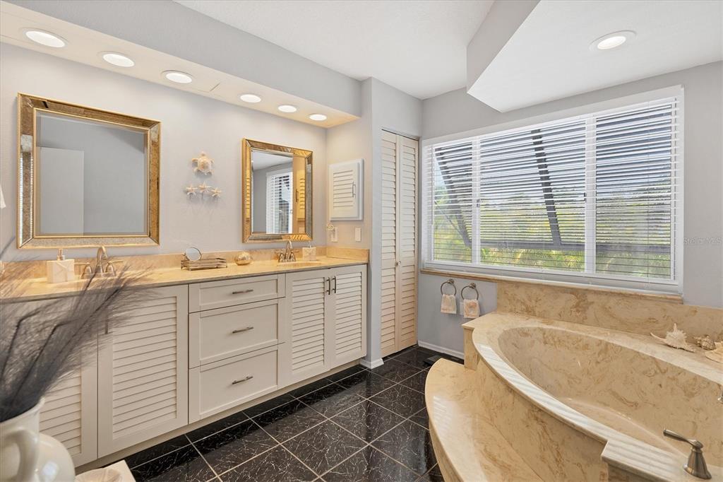 245 Spaniards Road Placida, FL 33946 - Photo 28 of 65 a bathroom with a granite countertop tub a sink and a large window