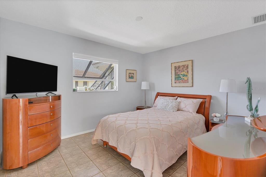 245 Spaniards Road Placida, FL 33946 - Photo 36 of 65 a bedroom with a bed and a flat screen tv