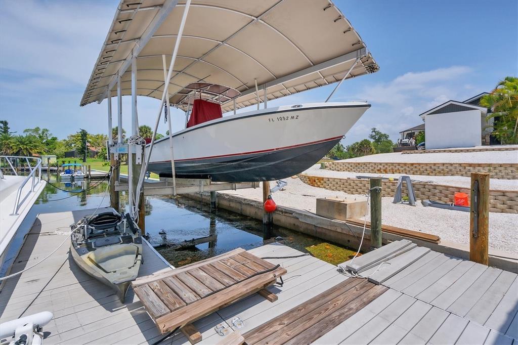 245 Spaniards Road Placida, FL 33946 - Photo 52 of 65 a view of a patio with table and chairs potted plants with wooden floor