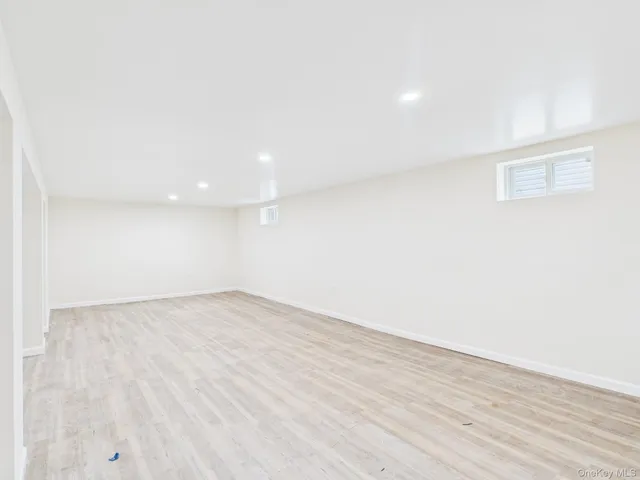 a view of an empty room with wooden floor and closet