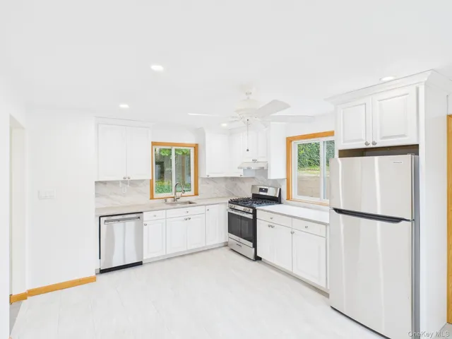 a kitchen with white cabinets and white appliances