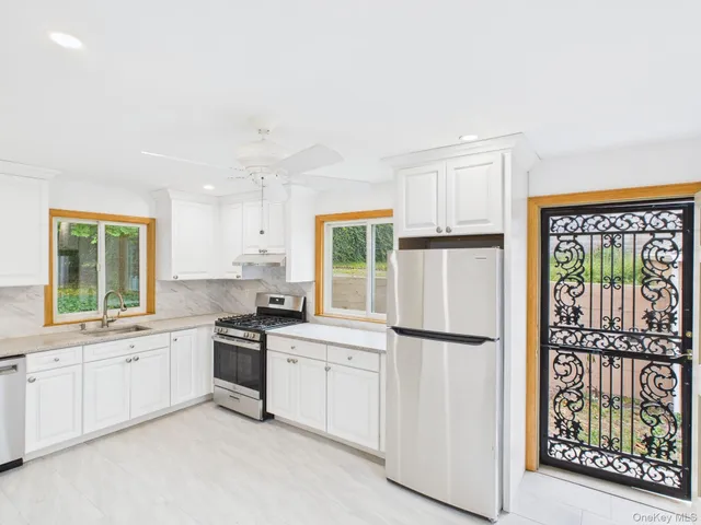 a kitchen with white cabinets and white appliances