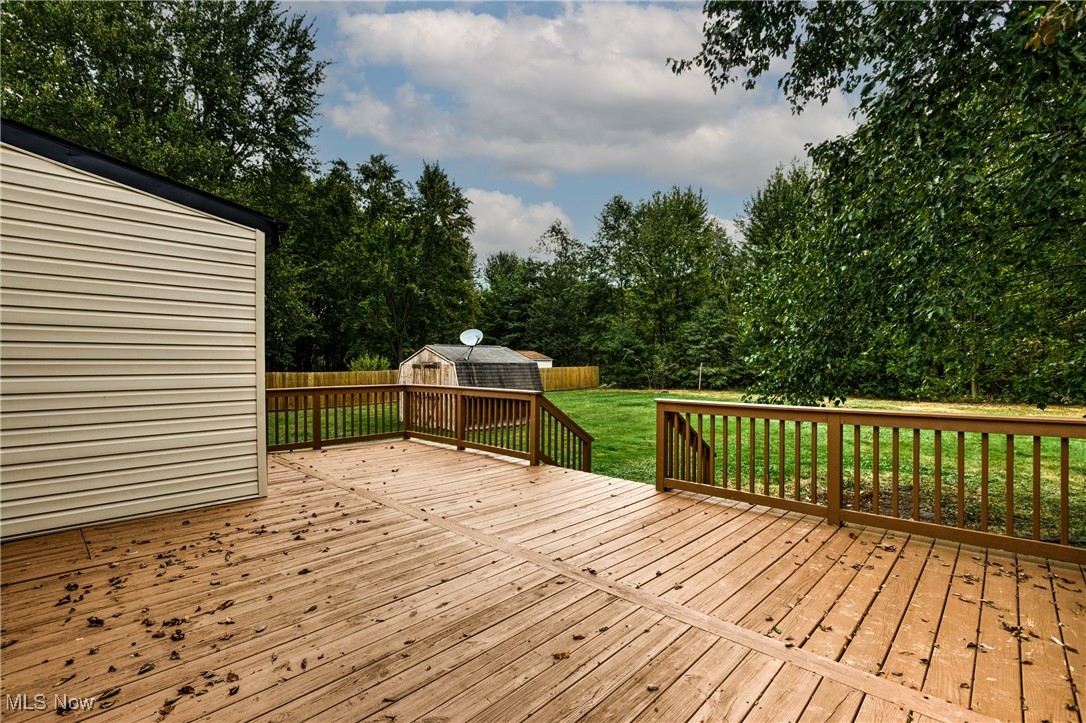 3691 Lyntz Road Warren, OH 44481 - Photo 30 of 36 Wooden deck featuring a fenced backyard, a storage unit, and view of scattered trees