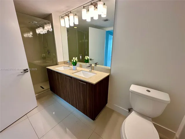 a bathroom with a toilet sink vanity and mirror