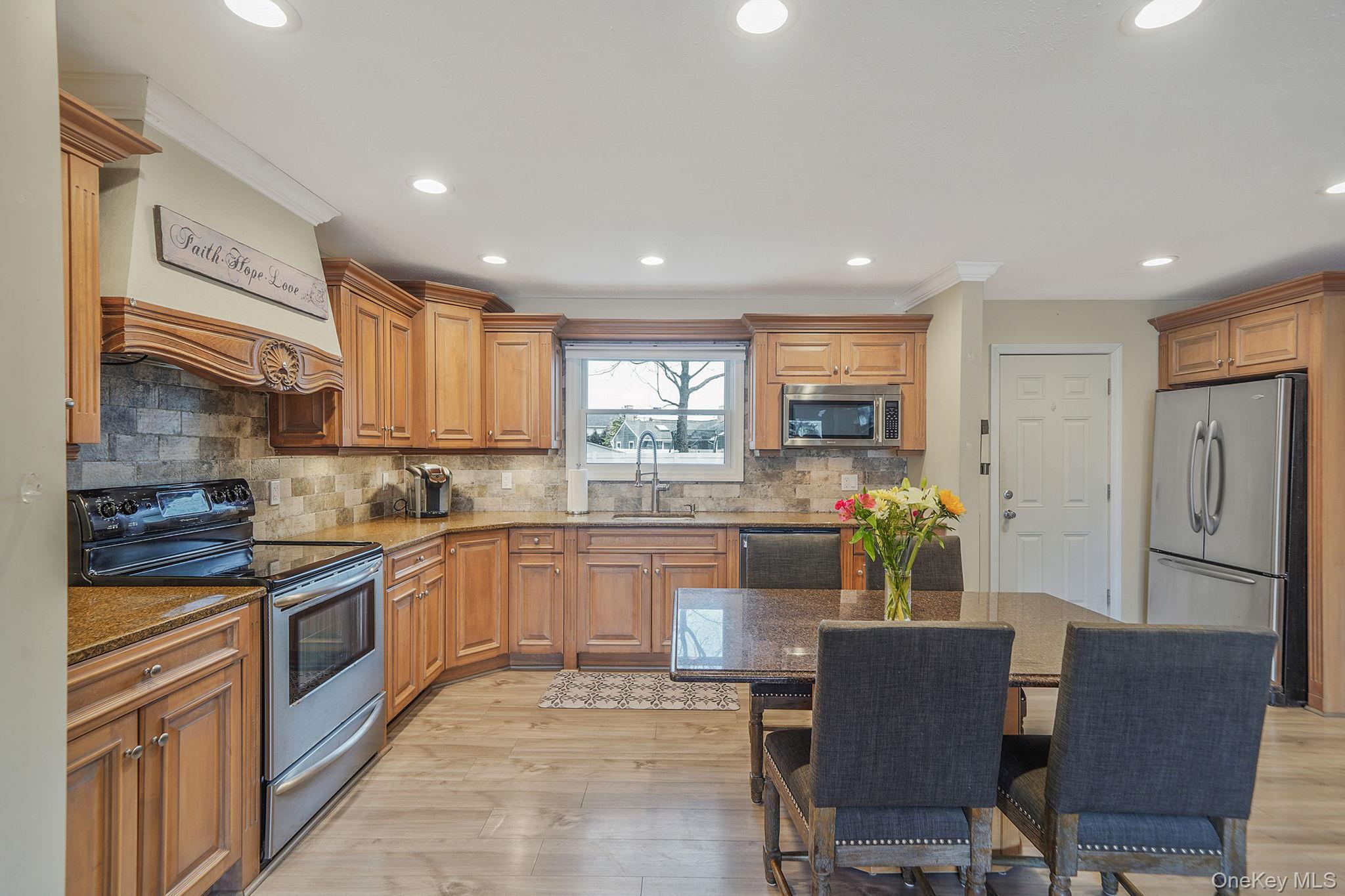 11 Nehring Avenue Babylon, NY 11702 - Photo 6 of 27 a kitchen with stainless steel appliances granite countertop a refrigerator and a stove top oven